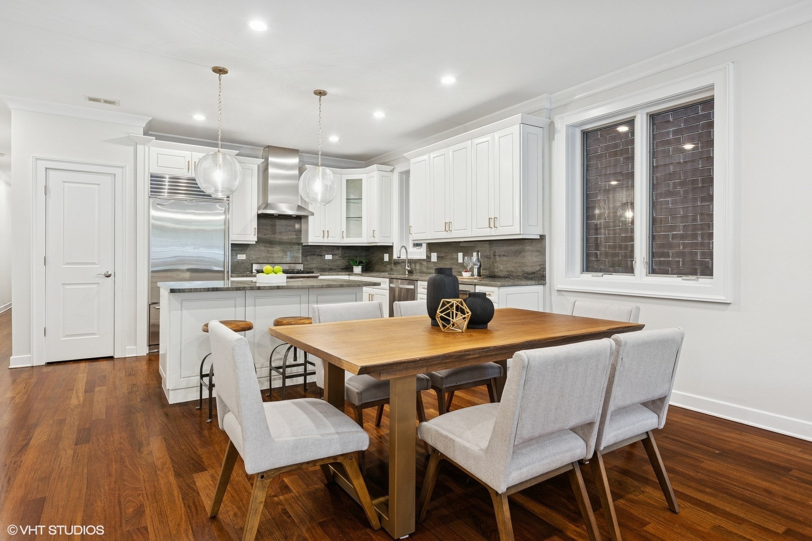 1035 West Monroe Street, Unit 1 Chicago, IL 60607 - Photo 5 of 27 a kitchen with stainless steel appliances granite countertop a table chairs sink refrigerator and cabinets