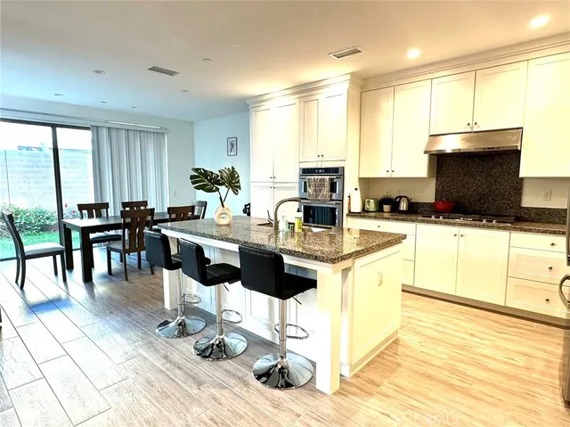 a kitchen with stainless steel appliances kitchen island granite countertop a sink and cabinets