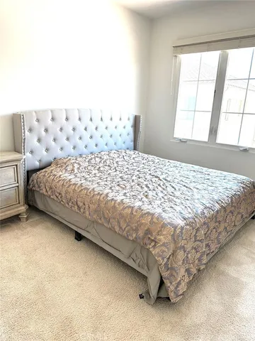 a bed sitting in a bedroom next to a window