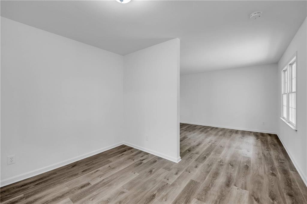 1586 Kings Road Marietta, GA 30062 - Photo 14 of 66 a view of an empty room with wooden floor and a window