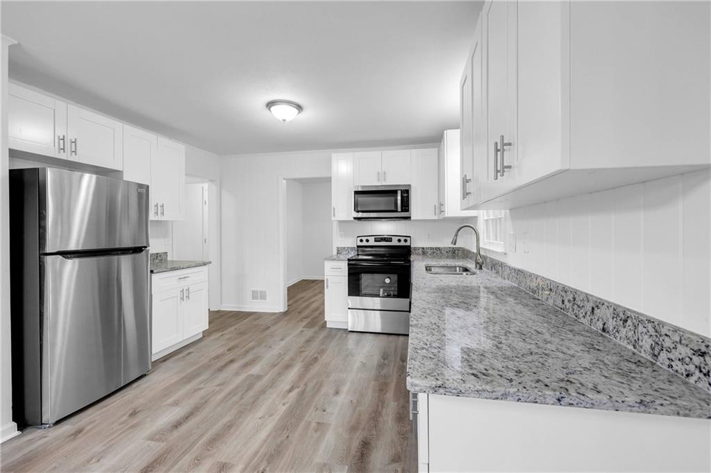 1586 Kings Road Marietta, GA 30062 - Photo 16 of 66 a kitchen with granite countertop a refrigerator stove and oven