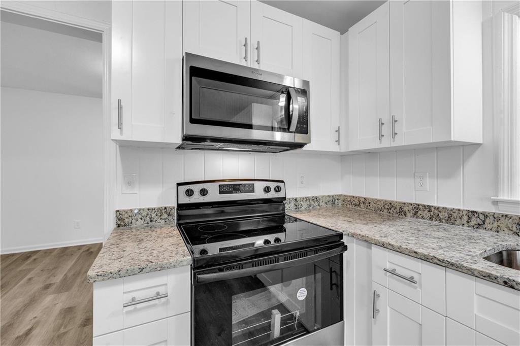 1586 Kings Road Marietta, GA 30062 - Photo 18 of 66 a kitchen with granite countertop a stove and a microwave