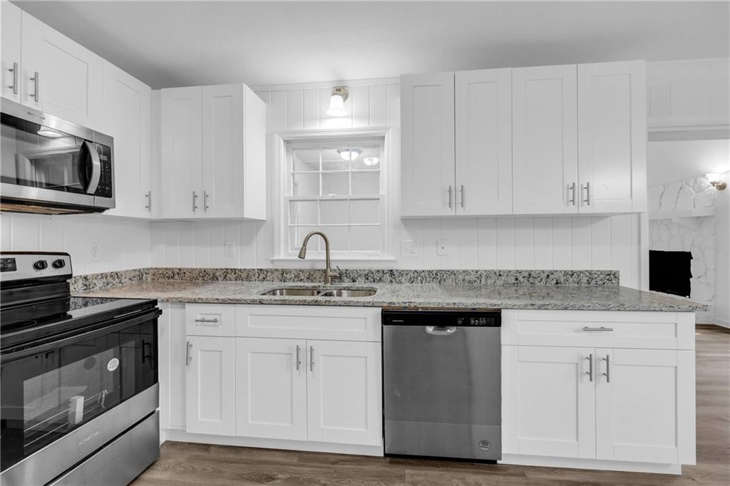 1586 Kings Road Marietta, GA 30062 - Photo 20 of 66 a kitchen with granite countertop white cabinets and stainless steel appliances