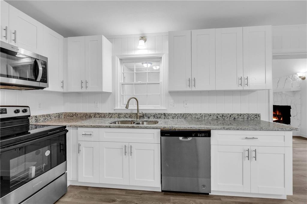 1586 Kings Road Marietta, GA 30062 - Photo 21 of 66 a kitchen with white cabinets and stainless steel appliances