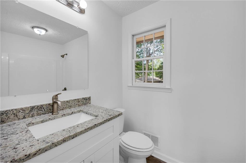 1586 Kings Road Marietta, GA 30062 - Photo 36 of 66 a bathroom with a granite countertop sink toilet a mirror and window