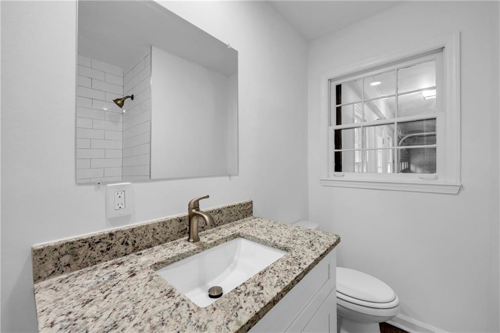 1586 Kings Road Marietta, GA 30062 - Photo 46 of 66 a bathroom with a granite countertop sink a toilet and a mirror