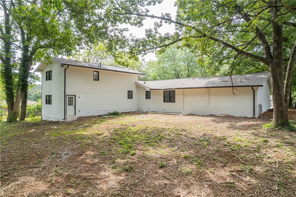 1586 Kings Road Marietta, GA 30062 - Photo 5 of 66 a backyard of a house with large trees and garage