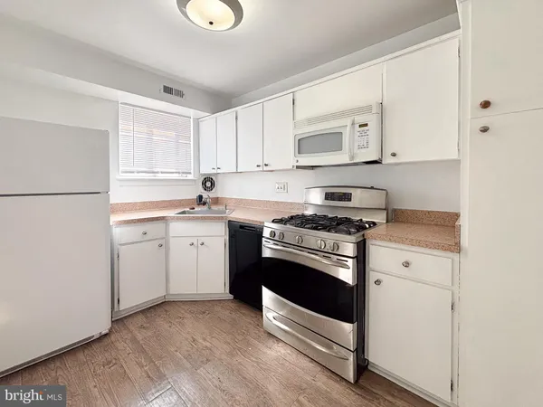 a kitchen with cabinets appliances and a sink