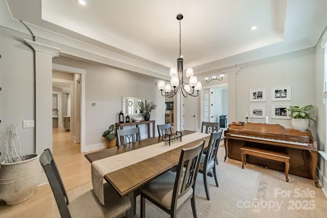 a dining room with furniture a chandelier and wooden floor
