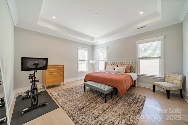 a spacious bedroom with a bed and a flat screen tv