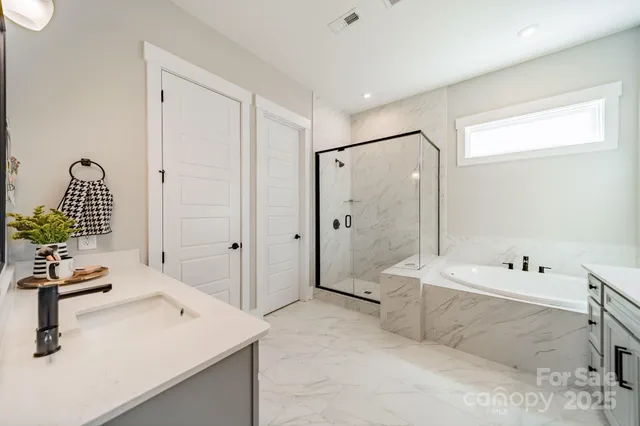 a bathroom with a tub sink and mirror
