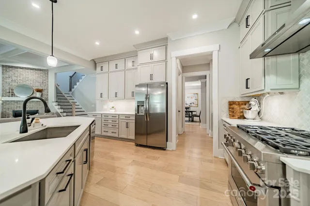 a kitchen with stainless steel appliances granite countertop a sink stove and refrigerator