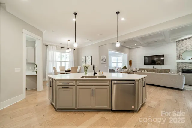 a kitchen with kitchen island a sink a stove a dining table and chairs