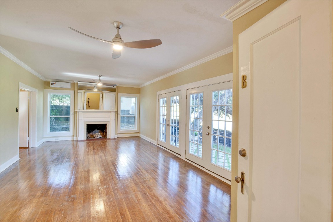 1115 Enfield Road, Unit B Austin, TX 78703 - Photo 12 of 34 a view of an empty room with wooden floor fireplace and a window