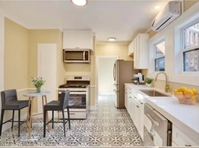 a kitchen with stainless steel appliances granite countertop a stove a sink and a refrigerator