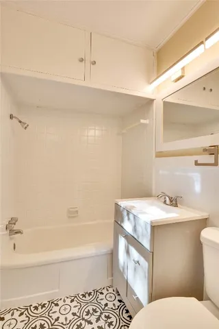 a bathroom with a sink toilet vanity and bathtub