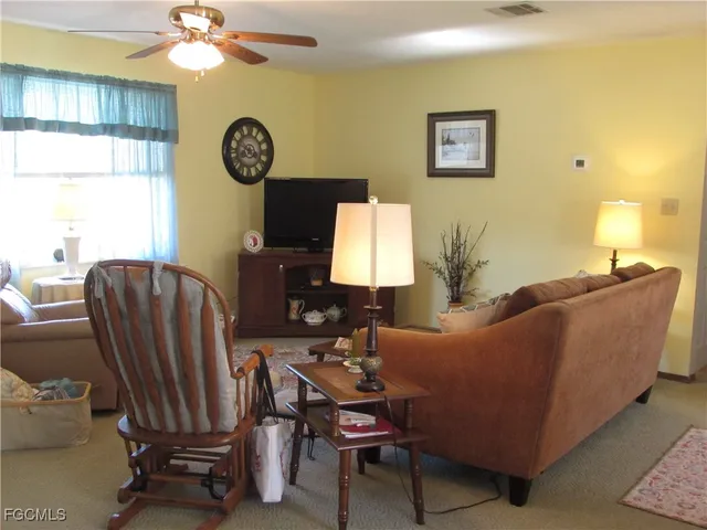 a living room with furniture a clock and a window