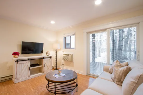 a living room with furniture a flat screen tv and a window