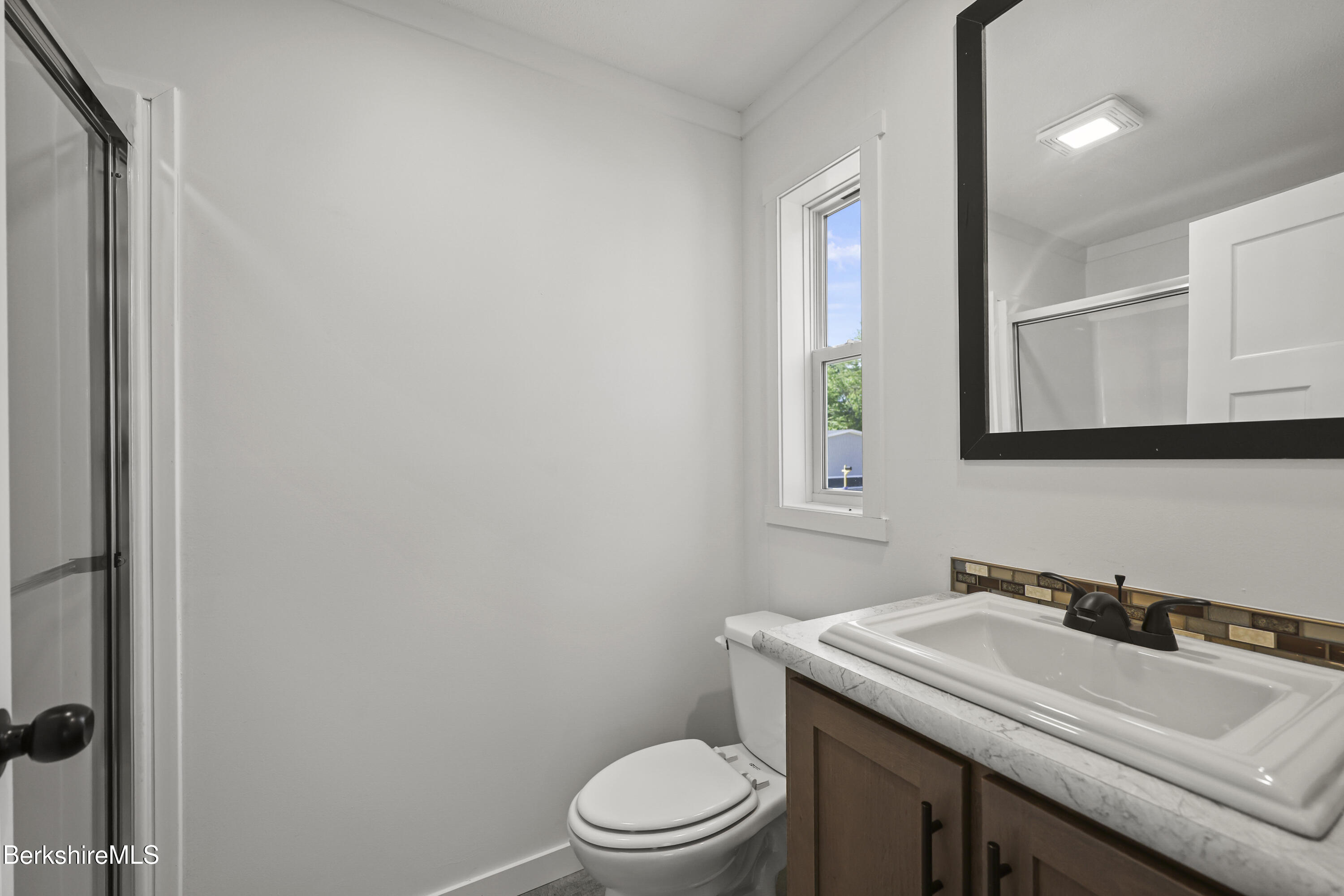 395 Cheshire Road, Unit 102 Pittsfield, MA 01201 - Photo 21 of 28 a bathroom with a sink toilet and mirror