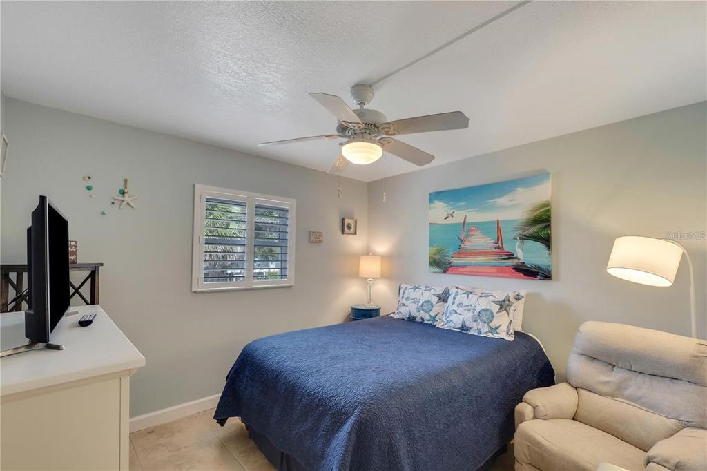 5031 North Beach Road, Unit 116 Englewood, FL 34223 - Photo 21 of 41 a bedroom with a bed and a flat screen tv