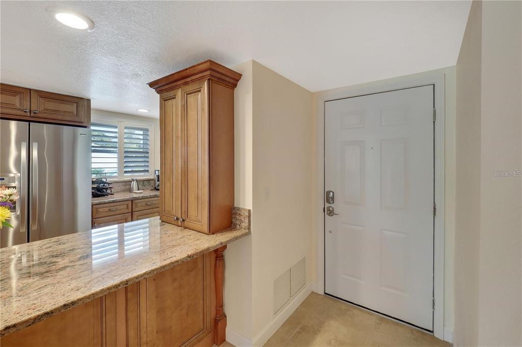 5031 North Beach Road, Unit 116 Englewood, FL 34223 - Photo 10 of 41 a kitchen with stainless steel appliances granite countertop a refrigerator and a sink