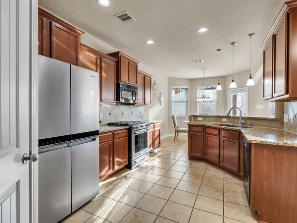 a large kitchen with stainless steel appliances cabinets a sink and a counter top space
