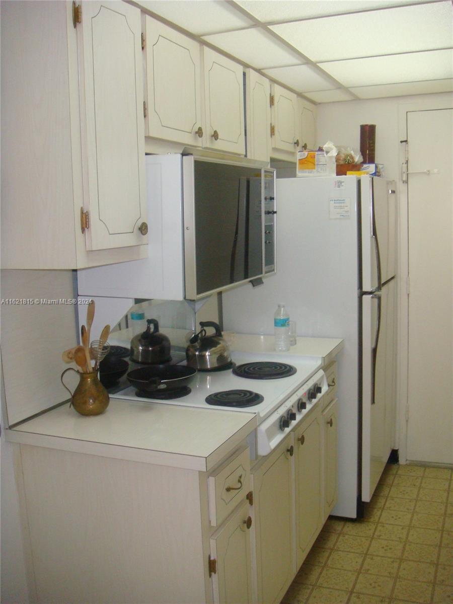 5401 Collins Avenue, Unit 1012 Miami Beach, FL 33140 - Photo 5 of 11 a view of a kitchen with sink and refrigerator