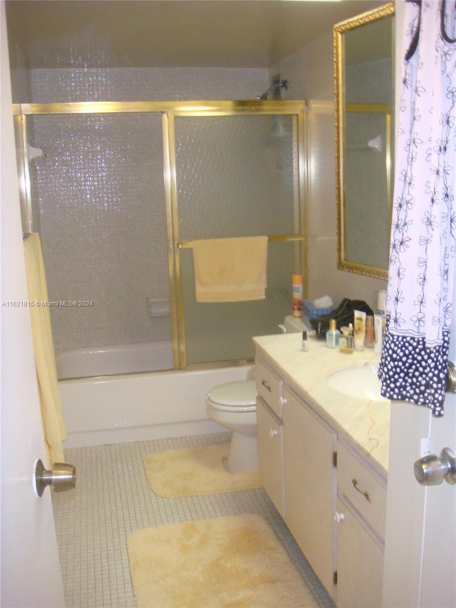 5401 Collins Avenue, Unit 1012 Miami Beach, FL 33140 - Photo 7 of 11 a bathroom with a sink a toilet and shower
