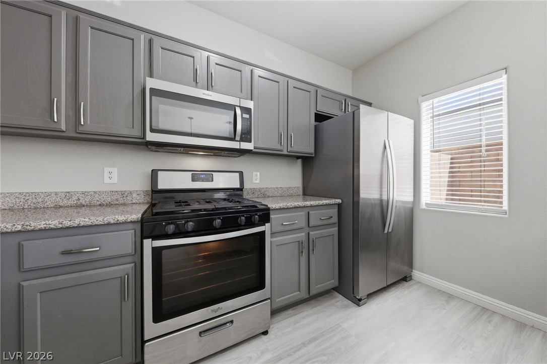 6312 Sandy Ridge Street, Unit 3102 North Las Vegas, NV 89081 - Photo 7 of 31 A well-appointed kitchen features sleek gray cabinetry and robust stainless steel appliances.
