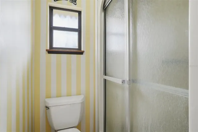 a bathroom with a granite countertop toilet and a shower