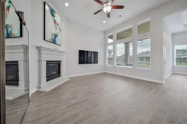 wooden floor fireplace and windows in an empty room
