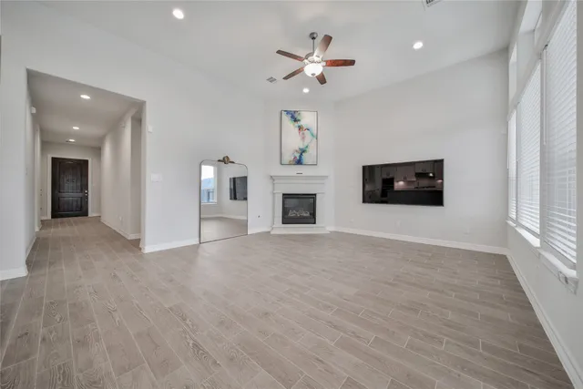 a view of an empty room with a fireplace and a window