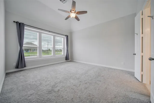 an empty room with windows and fan