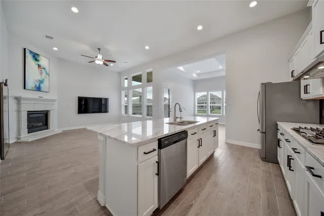 a large kitchen with stainless steel appliances granite countertop a lot of counter space and wooden floor