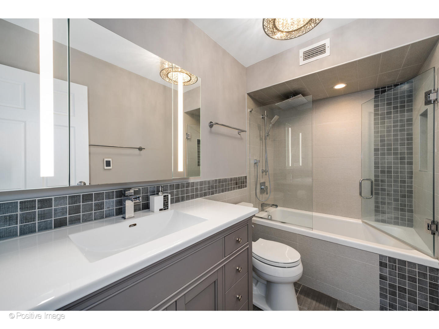 6007 North Sheridan Road, Unit 8B Chicago, IL 60660 - Photo 14 of 23 a bathroom with a sink a toilet a mirror and bathtub