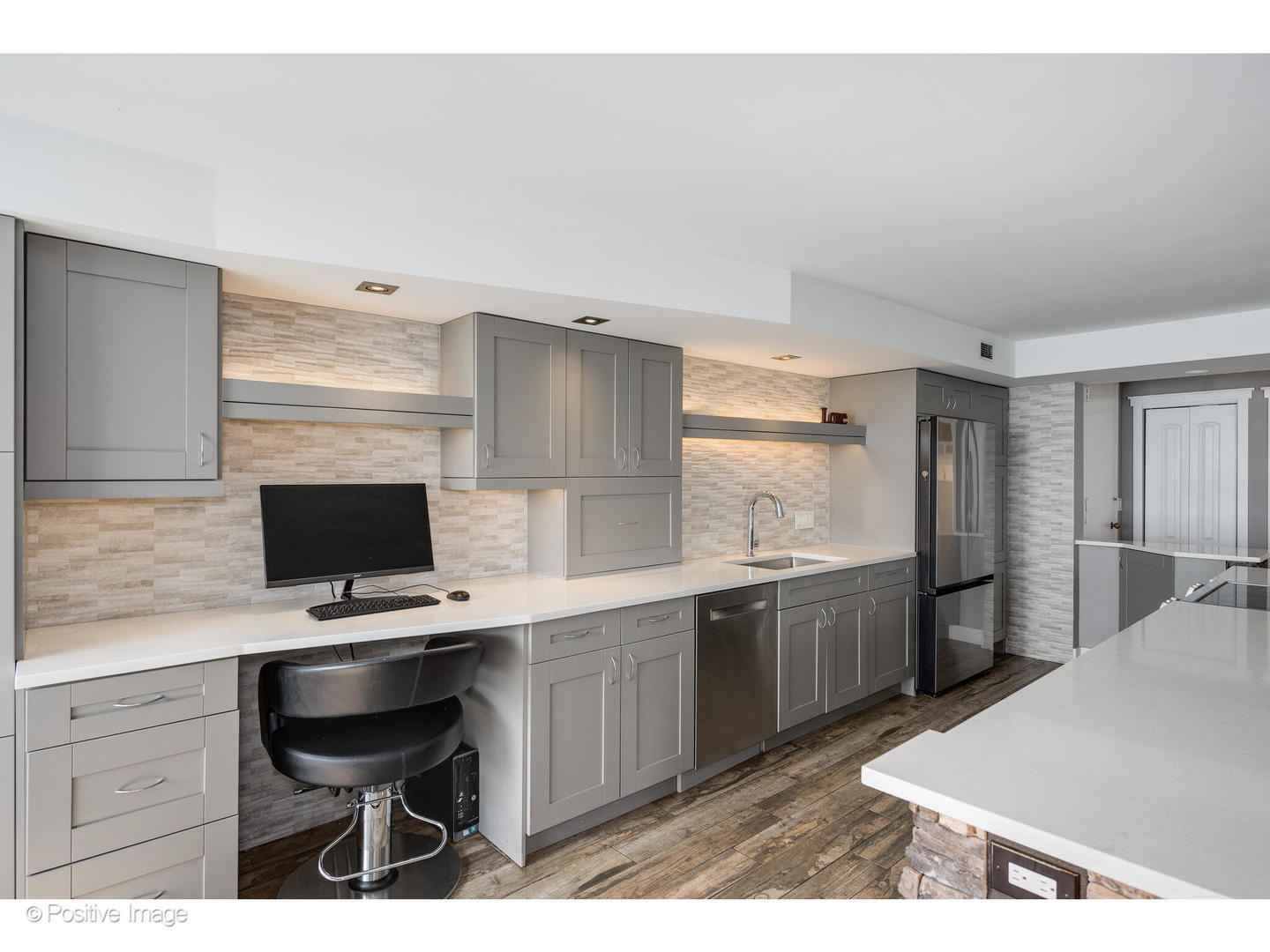 6007 North Sheridan Road, Unit 8B Chicago, IL 60660 - Photo 9 of 23 a kitchen with stainless steel appliances kitchen island granite countertop a sink dishwasher a stove a refrigerator and a dining table with wooden floor