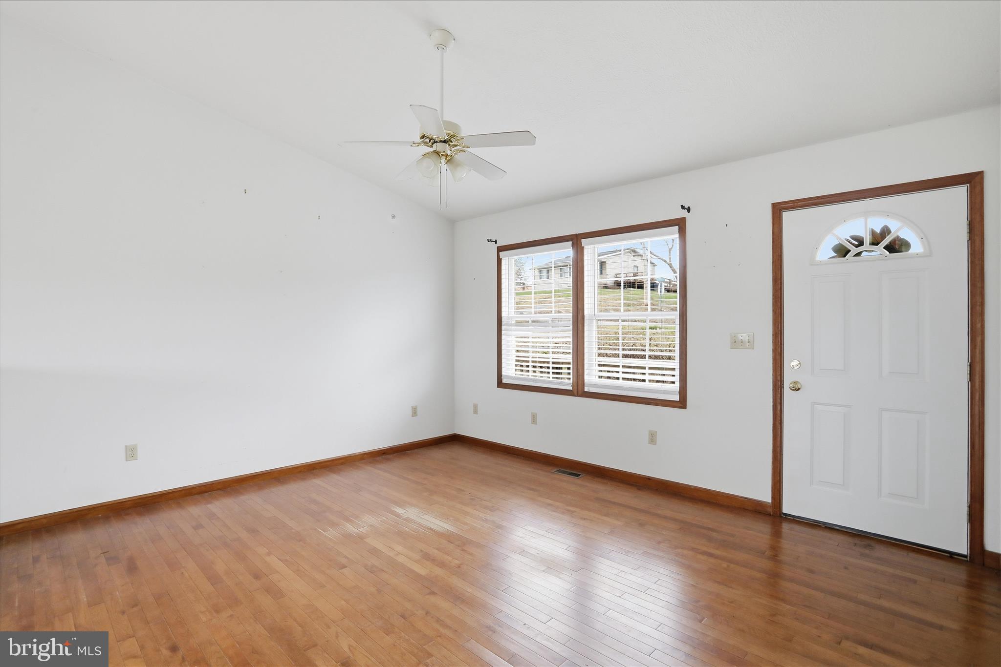 316 East Ridge Loop Road Romney, WV 26757 - Photo 6 of 33 a view of an empty room with a window and wooden floor