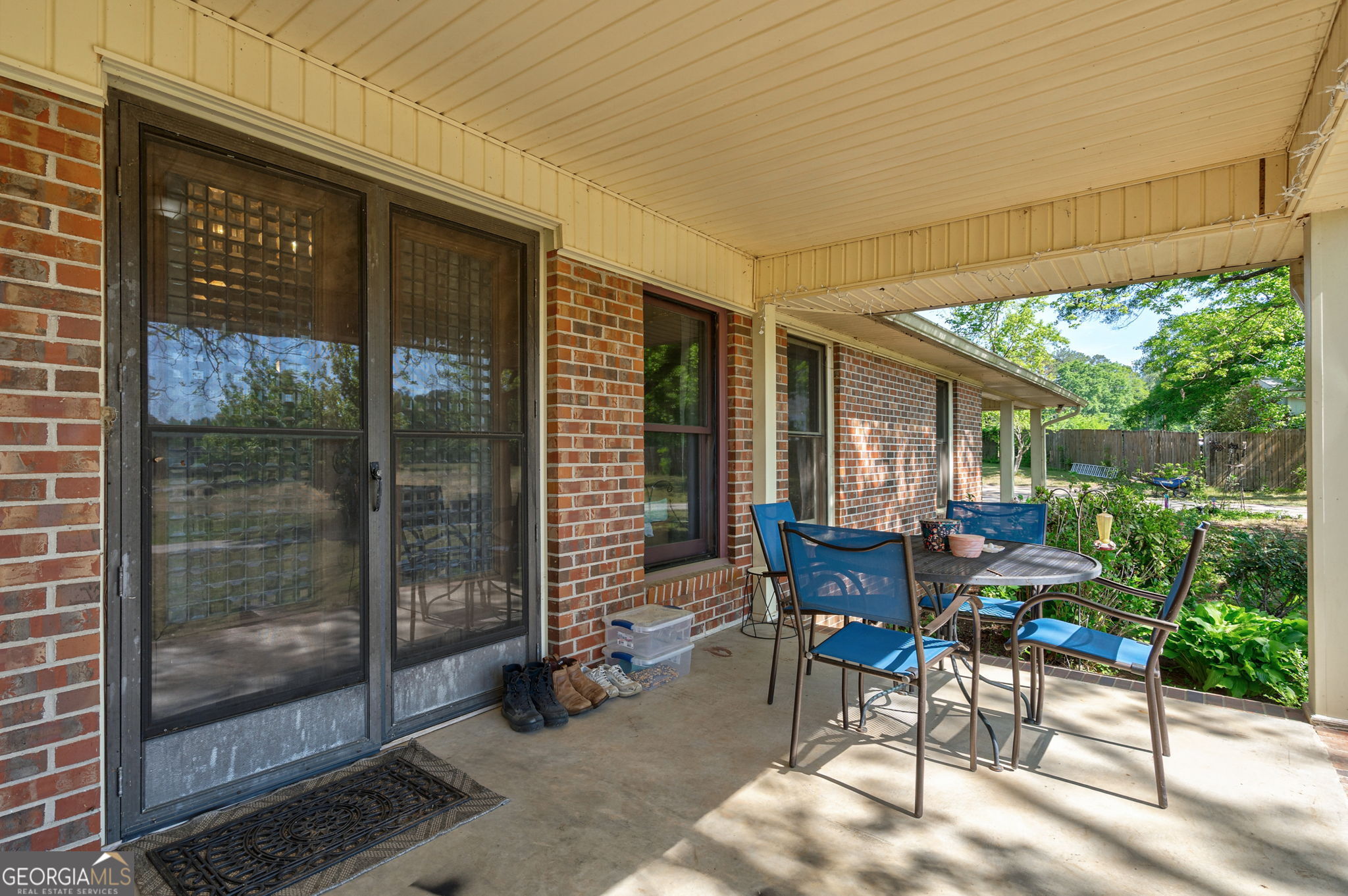 1281 Apalachee River Road Madison, GA 30650 - Photo 69 of 98 a view of a patio with table and chairs and floor to ceiling window next to a yard