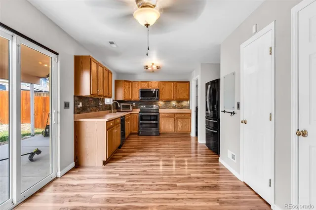 a kitchen with a refrigerator a stove top oven a chimney cabinets and stainless steel appliances