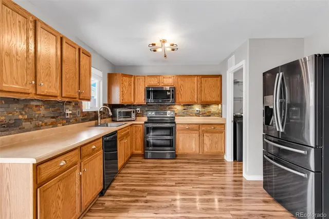 a kitchen with granite countertop stainless steel appliances and window