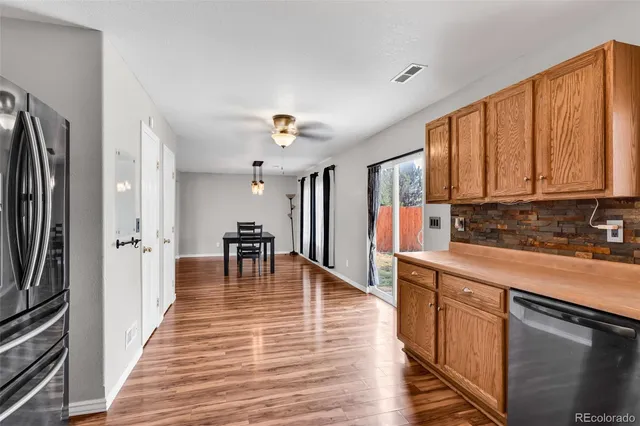 a kitchen with stainless steel appliances granite countertop a refrigerator stove microwave and cabinets with wooden floor