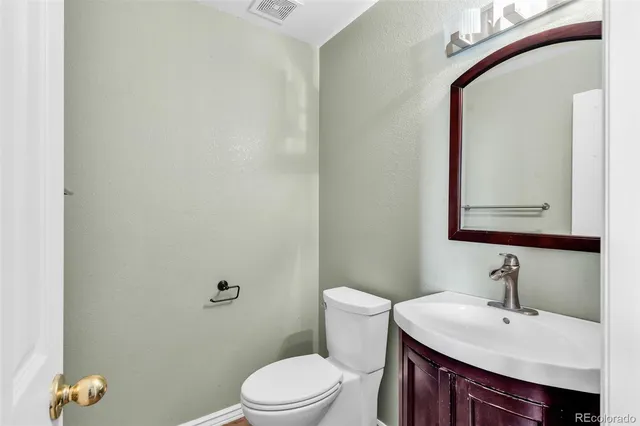 a bathroom with a sink vanity mirror and toilet