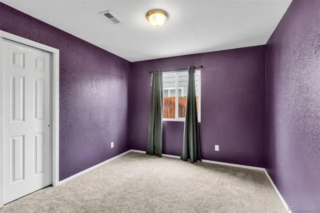 an empty room with windows and closet
