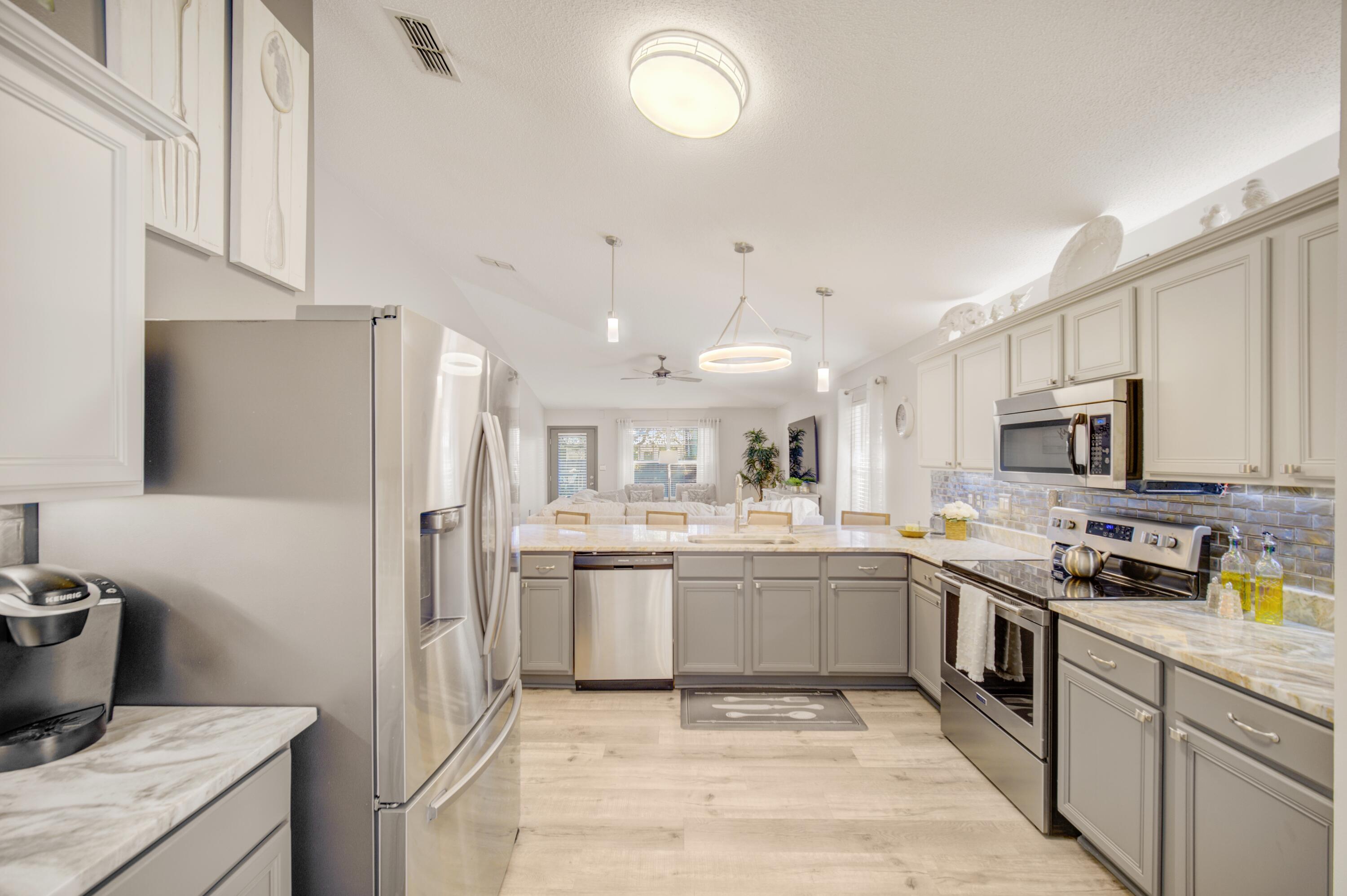 35 Red Bay Court Santa Rosa Beach, FL 32459 - Photo 27 of 73 a large kitchen with stainless steel appliances granite countertop a sink and dishwasher a refrigerator with wooden cabinets