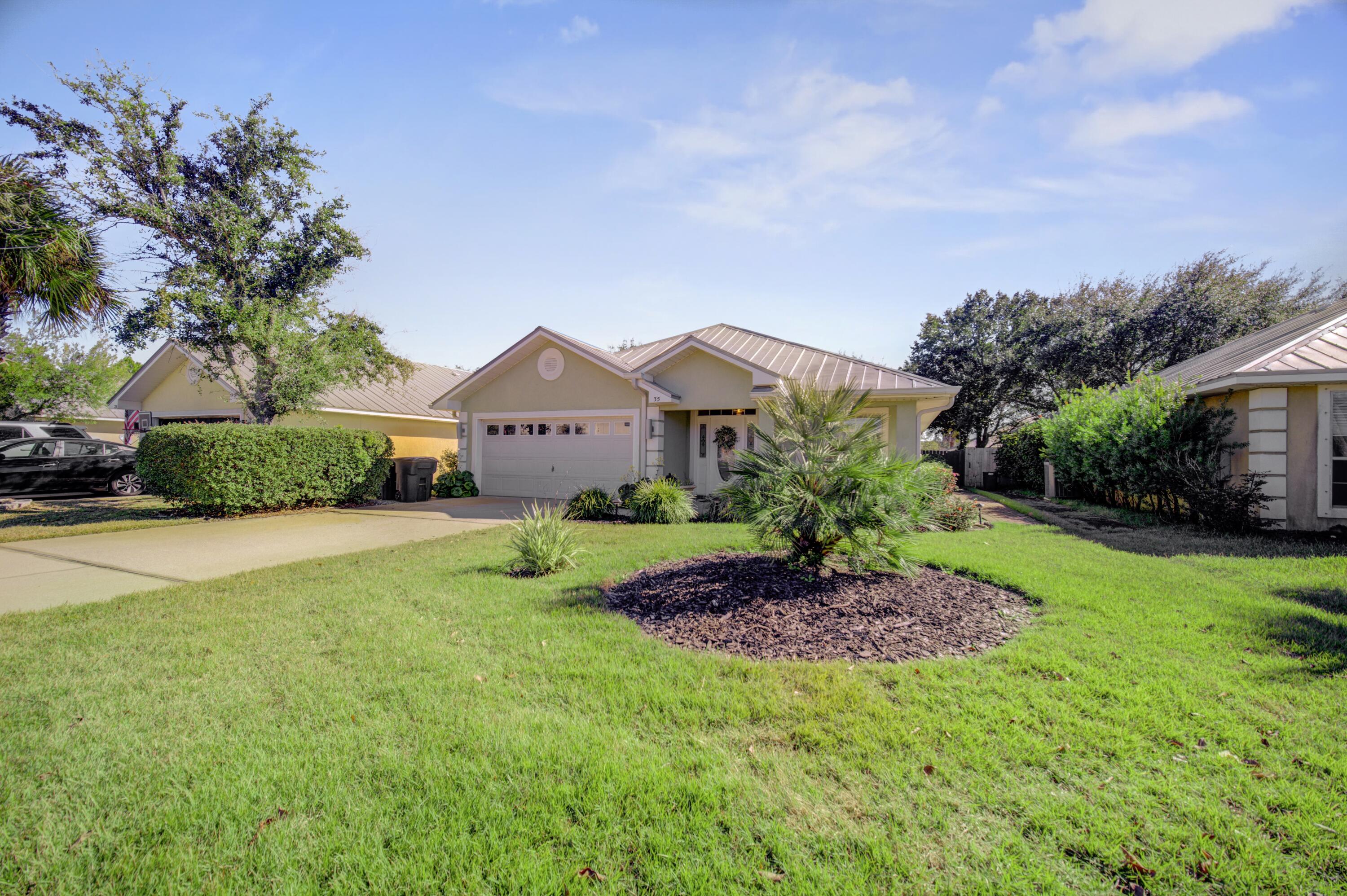 35 Red Bay Court Santa Rosa Beach, FL 32459 - Photo 4 of 73 a front view of a house with a yard and garage