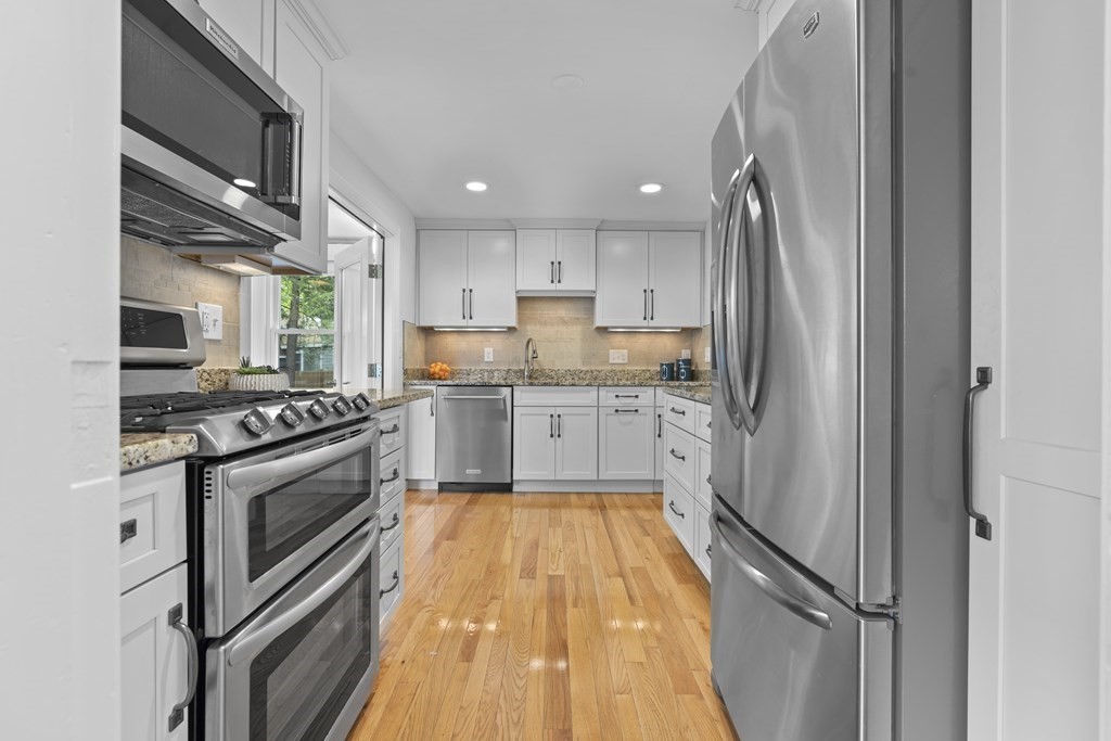 9 Ferndale Road Natick, MA 01760 - Photo 6 of 24 a kitchen with stainless steel appliances granite countertop a stove top oven a sink and white cabinets