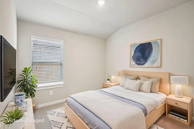 a bedroom with a bed and a potted plant