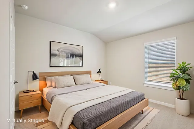 a bedroom with a large bed and a potted plant