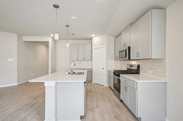 a kitchen with stainless steel appliances granite countertop a sink stove and refrigerator