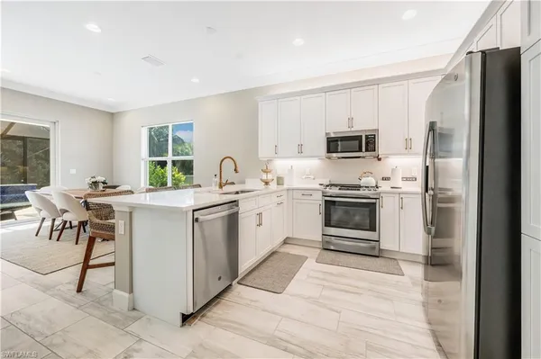 a kitchen with white cabinets and white appliances